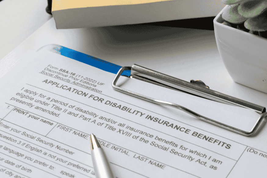 Formular für Leistungen der Berufsunfähigkeitsversicherung mit Stift auf einem Klemmbrett.