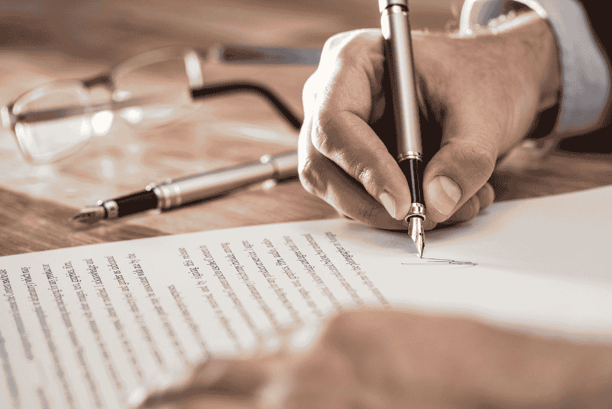 Hand unterschreibt Ratenkaufvertrag und prüft Bedingungen für BNPL-Finanzierung