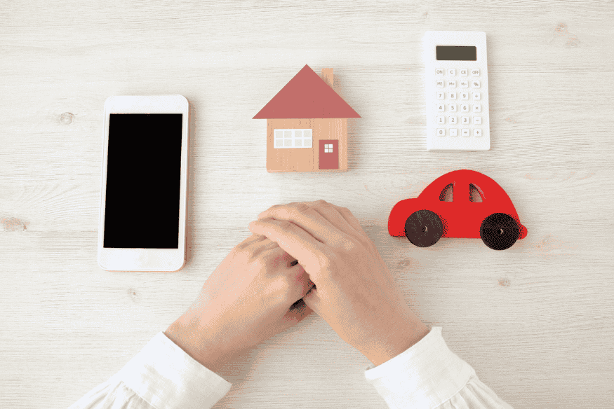 Smartphone, Haus, Auto und Taschenrechner als Symbole für laufende Kosten und Preisvergleich im Alltag