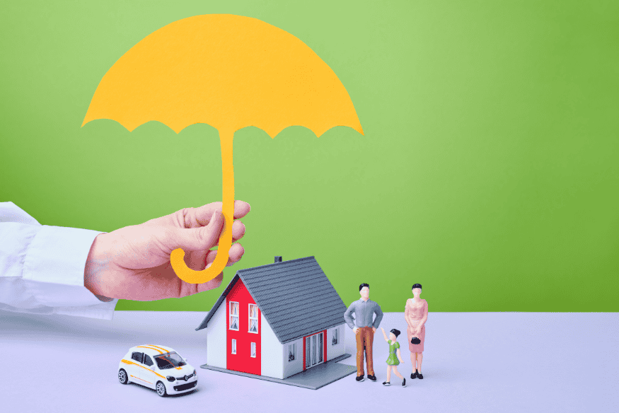 Hand hält gelben Schutzschirm über Modellhaus, Auto und Familie als Symbol für umfassende Pflege- und Vorsorgeabsicherung.