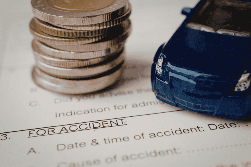 Münzstapel und Modellauto liegen auf einem Schadensformular – Darstellung möglicher Kosten ohne private Haftpflichtversicherung.