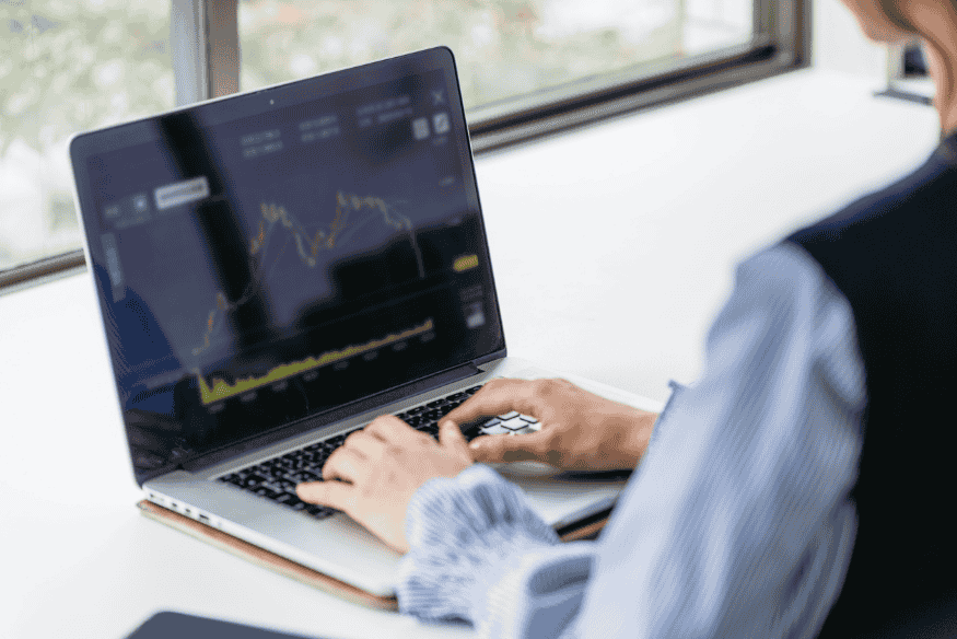 Person beobachtet Kursdiagramm auf dem Laptop, um ETF-Investments an die eigene Risikostrategie anzupassen