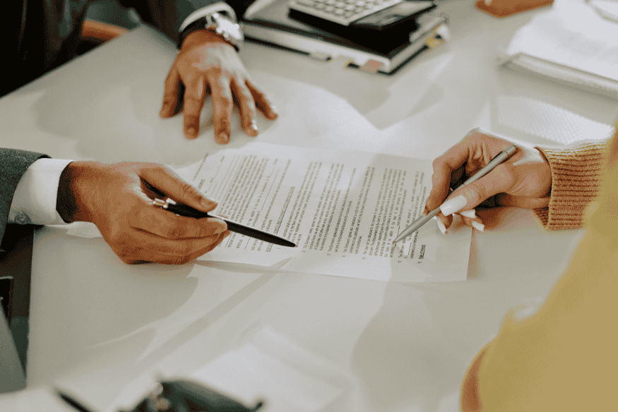 Zwei Personen prüfen gemeinsam einen Versicherungsvertrag und besprechen wichtige Details.