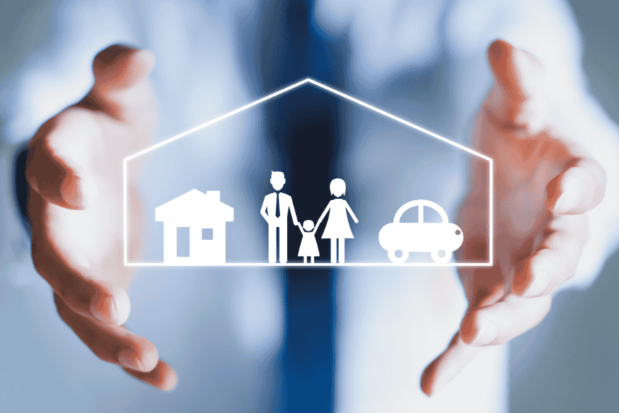 Geschäftsperson hält ein transparentes Symbol eines Hauses, einer Familie und eines Autos als Darstellung einer Risikolebensversicherung.