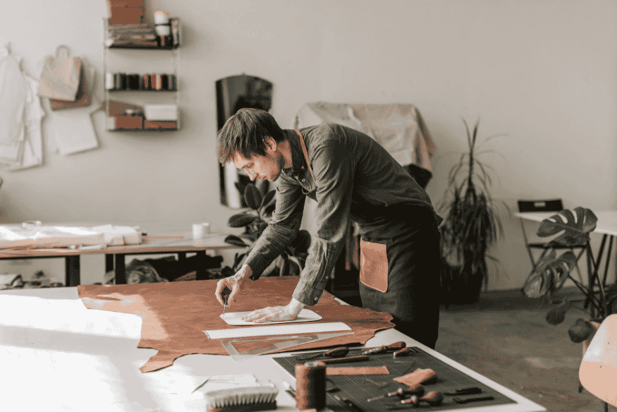Selbstständiger Handwerker im Atelier, der seine Arbeit plant und Steuerrücklagen für Vorauszahlungen berücksichtigt